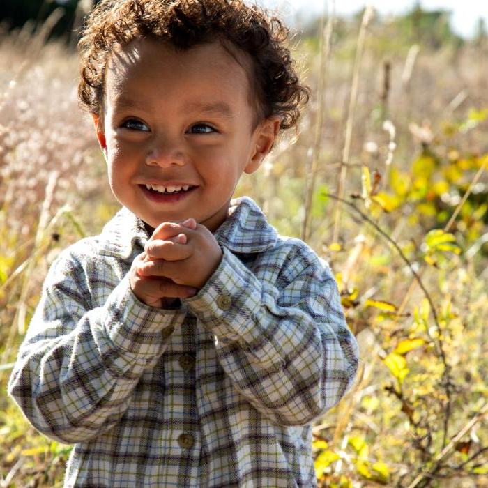 一个面带微笑的小男孩在密西西比河谷保护区内的一块田地里